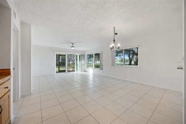 an empty room with windows and chandelier