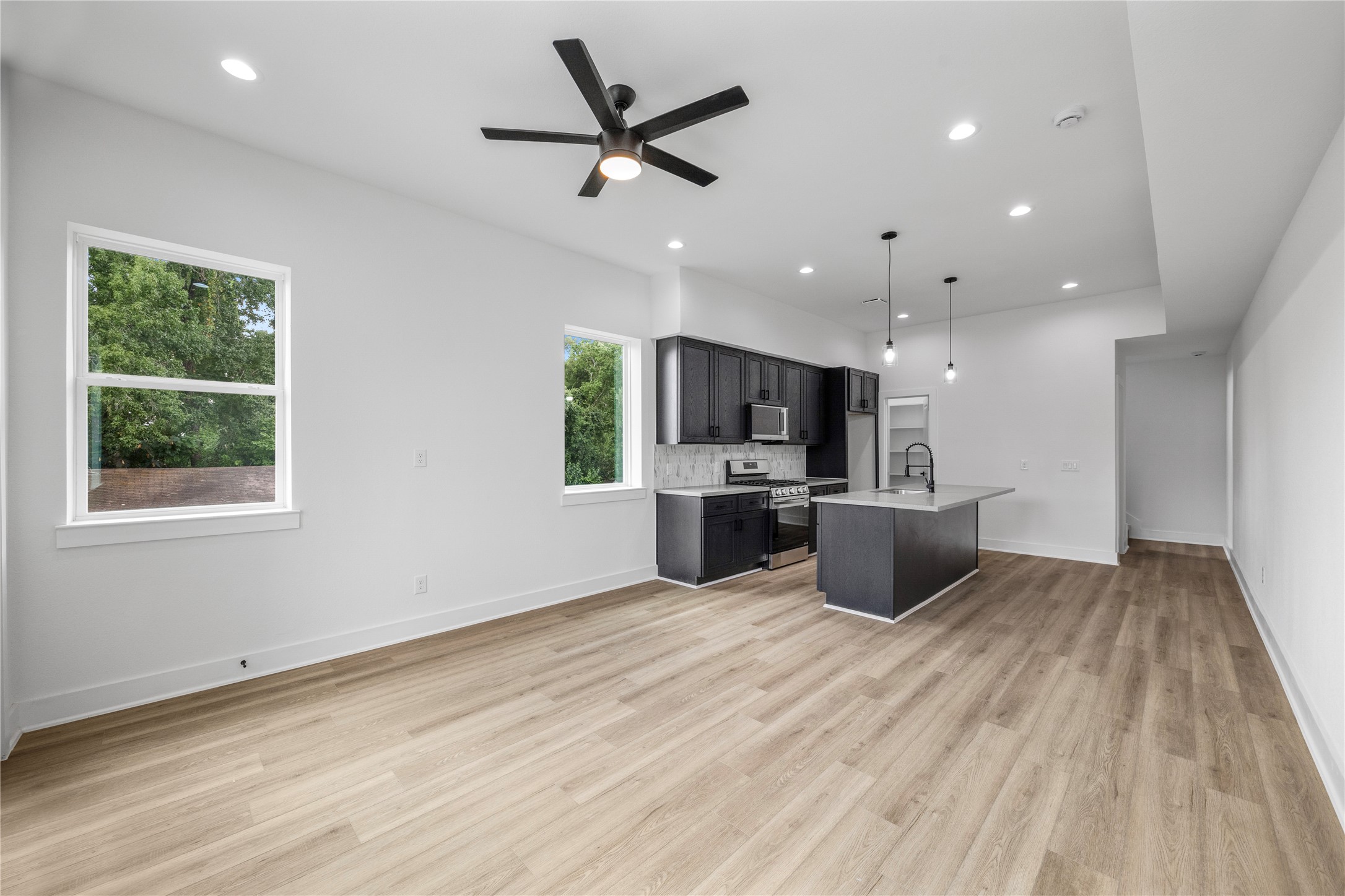 7901 Cora Street, Unit B Houston, TX 77088 - Photo 2 of 20 a kitchen with stainless steel appliances a kitchen island a stove a sink a window and a counter top space