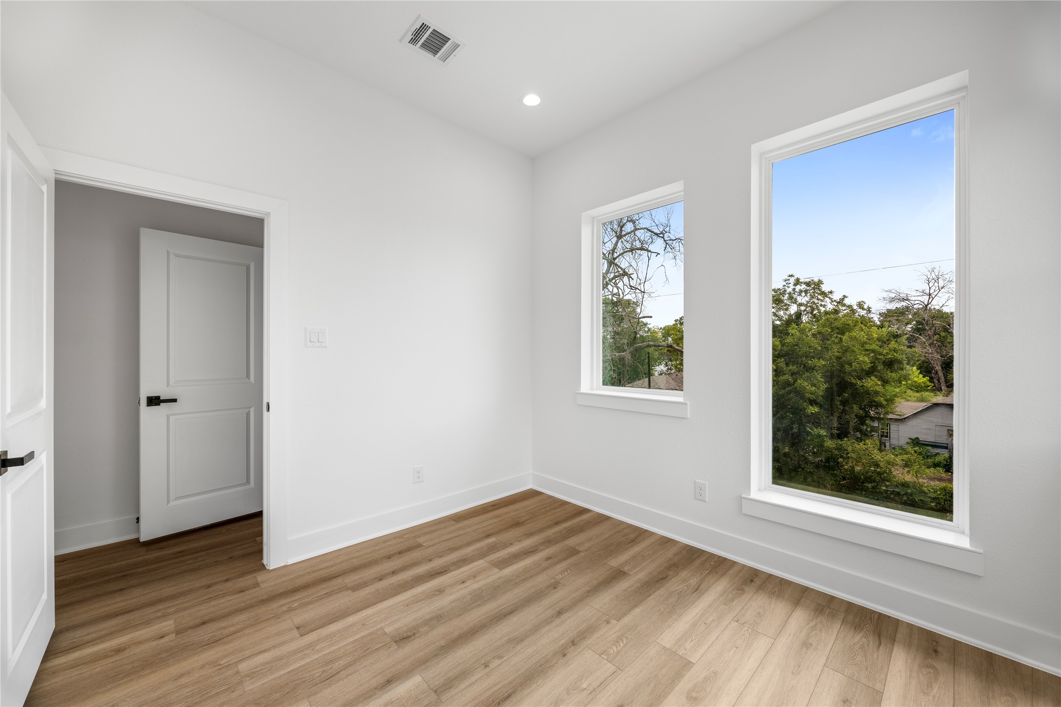 7901 Cora Street, Unit B Houston, TX 77088 - Photo 8 of 20 a view of an empty room with wooden floor and a window