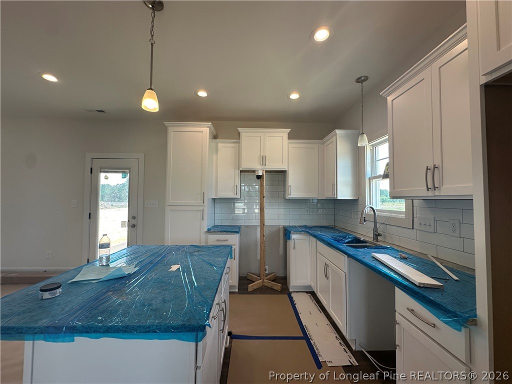 8383 Shannon Road Shannon, NC 28386 - Photo 7 of 17 a kitchen with kitchen island granite countertop a sink a counter top space appliances and cabinets