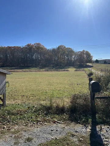 a view of swimming pool with lawn chairs and wooden fence