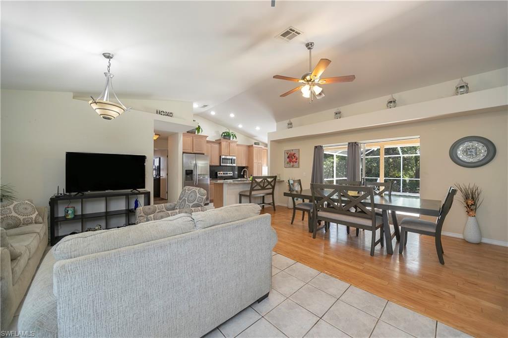 9084 Irving Road Fort Myers, FL 33967 - Photo 5 of 12 a living room with furniture a flat screen tv and kitchen view