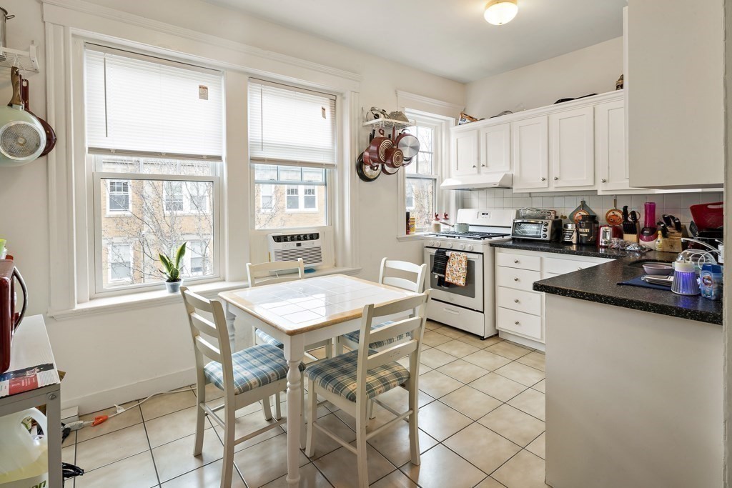 65 Lanark Road, Unit 7 Boston, MA 02135 - Photo 3 of 18 a kitchen with stainless steel appliances granite countertop a stove a sink and a refrigerator