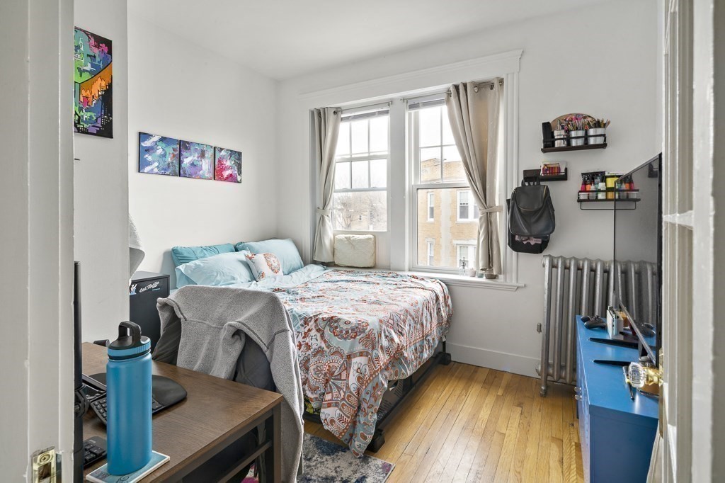 65 Lanark Road, Unit 7 Boston, MA 02135 - Photo 7 of 18 a bedroom with a bed a dresser next to a window