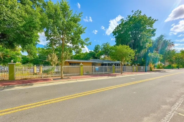 a view of a house with a backyard and a tree