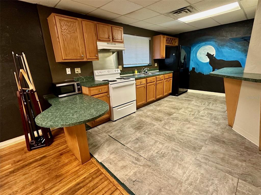 905 Southwest 8th Avenue Gainesville, FL 32601 - Photo 20 of 31 a kitchen with stainless steel appliances granite countertop a stove top oven a sink dishwasher and cabinets with wooden floor