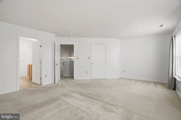 an empty room with windows and closet