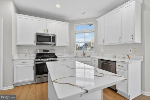 a kitchen with cabinets appliances a sink and a counter top space
