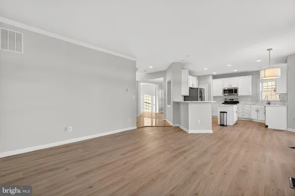 a view of a kitchen with wooden floor and a window