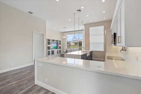 a kitchen with stainless steel appliances granite countertop a sink and a large window