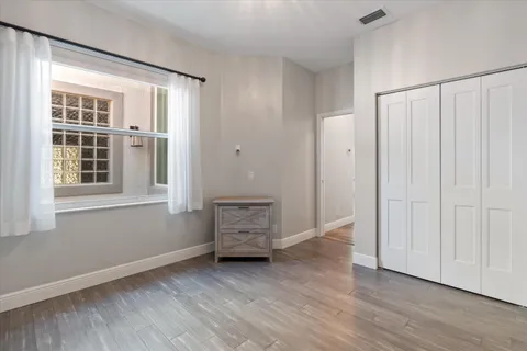 an empty room with wooden floor and windows