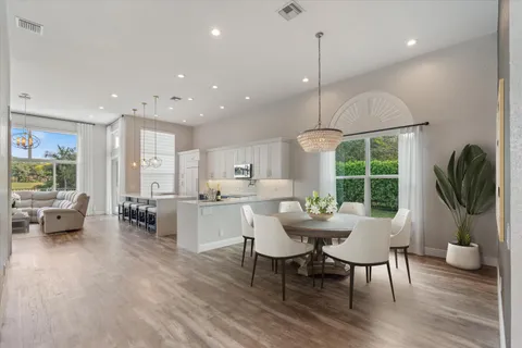 a dining room with furniture a chandelier and wooden floor