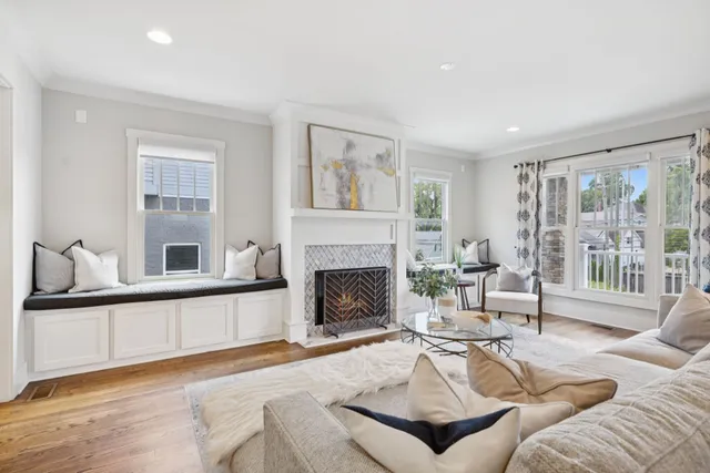 a living room with furniture a large window and a chandelier