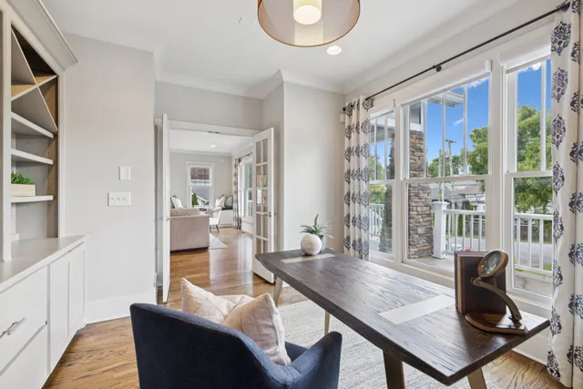 a living room with furniture kitchen view and a wooden floor