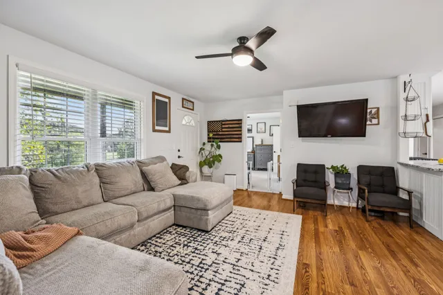 a living room with furniture a rug and a flat screen tv