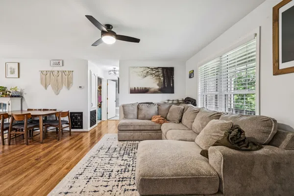a living room with furniture a dining table and wooden floor