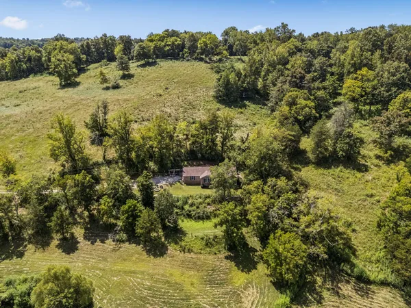 an aerial view of a house with a yard and lake view