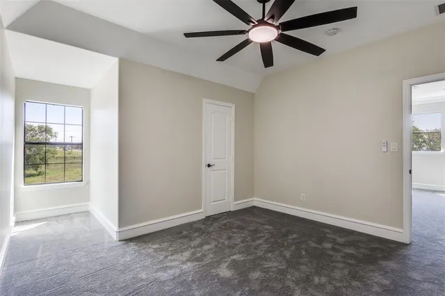 an empty room with closet and a ceiling fan
