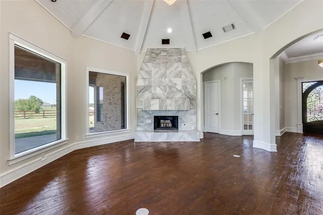 a view of an empty room with glass door and wooden floor