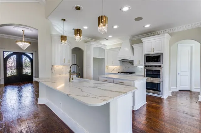 a kitchen with kitchen island a sink stainless steel appliances and cabinets