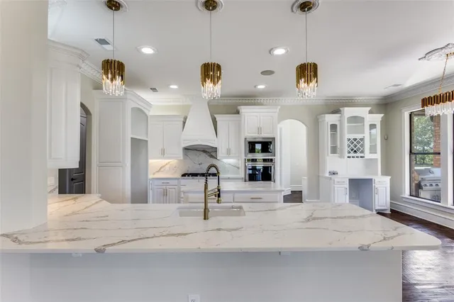 a large kitchen with stainless steel appliances kitchen island a chandelier