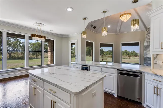 a kitchen with stainless steel appliances granite countertop a stove and a large window