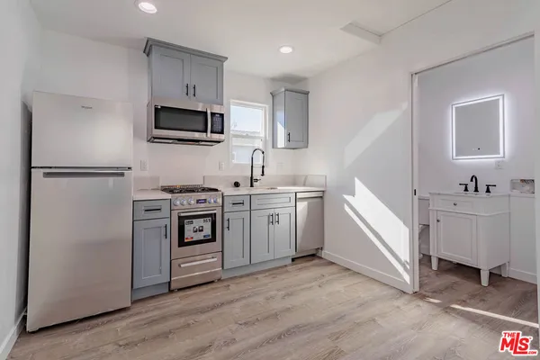 a kitchen with white cabinets and white appliances
