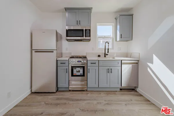 a kitchen with stainless steel appliances a sink stove and refrigerator