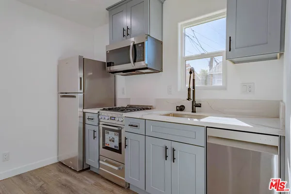 a kitchen with white cabinets stainless steel appliances and sink