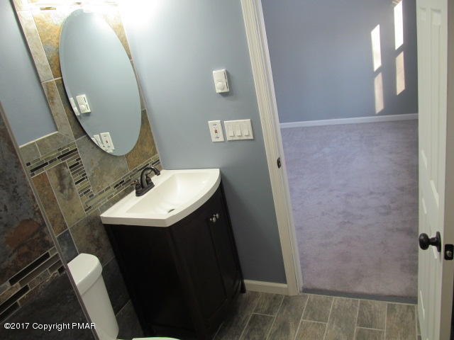 334 Canterbury Road Bushkill, PA 18324 - Photo 5 of 20 a bathroom with a sink a mirror and vanity