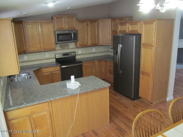 334 Canterbury Road Bushkill, PA 18324 - Photo 9 of 20 a kitchen with stainless steel appliances granite countertop a refrigerator a stove top oven a sink and dishwasher