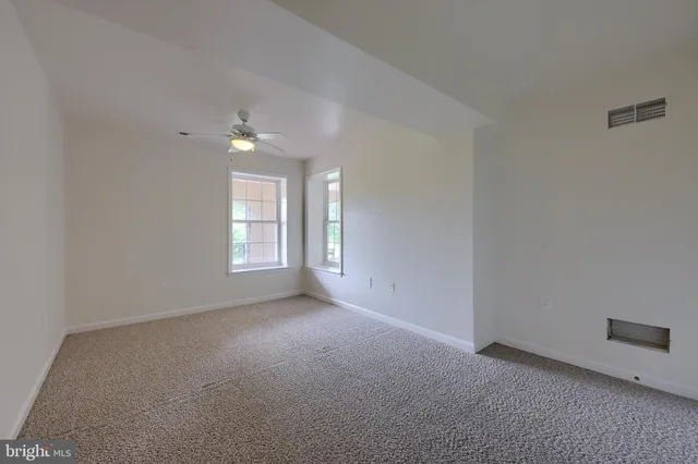 a front view of a house with a yard and potted plants
