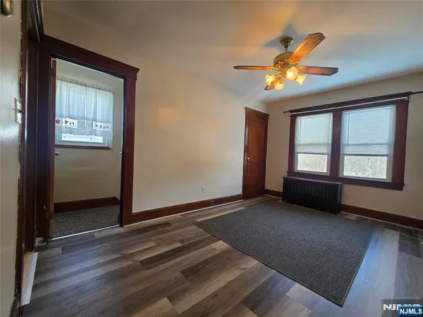 a view of an empty room with window and wooden floor