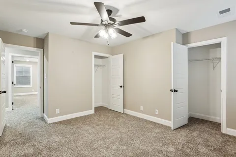 an empty room with a window and a fan