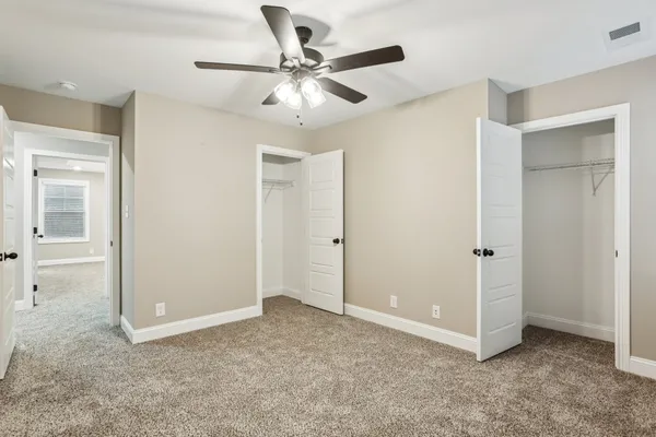 an empty room with a window and a fan