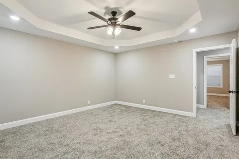 an empty room with closet and a chandelier fan