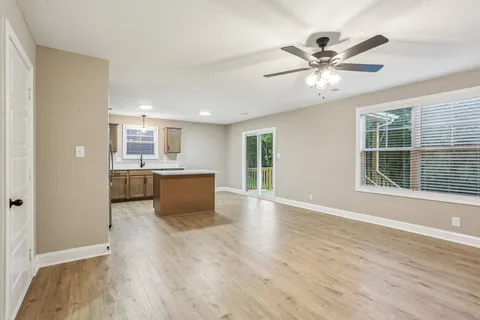 a view of a kitchen with a sink a window and wooden floor