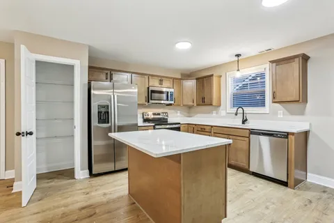 a kitchen with stainless steel appliances granite countertop a sink stove and refrigerator