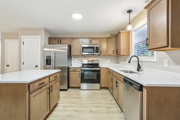 a kitchen with stainless steel appliances granite countertop a sink stove and refrigerator