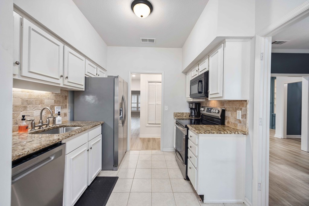 6500 Standing Boy Road, Unit 24 Columbus, GA 31904 - Photo 8 of 23 a kitchen with stainless steel appliances granite countertop a refrigerator oven a sink dishwasher and white cabinets with wooden floor