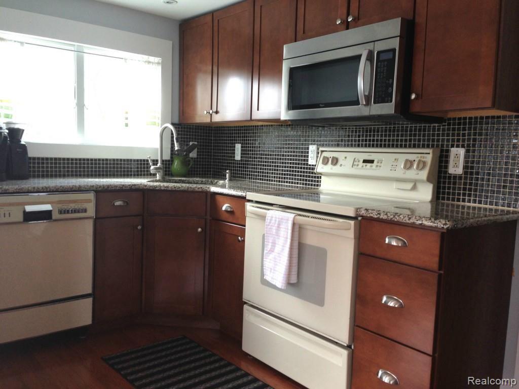 7218 Wiggins Road Howell, MI 48855 - Photo 4 of 25 Beautiful cabinets/hardward, granite and tile backsplash