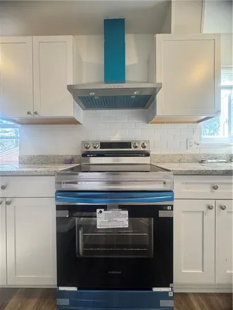 a stove top oven sitting inside of a kitchen