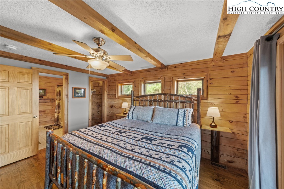 196 Eagle Nest Road Purlear, NC 28665 - Photo 21 of 36 a bedroom with a large bed and a chandelier