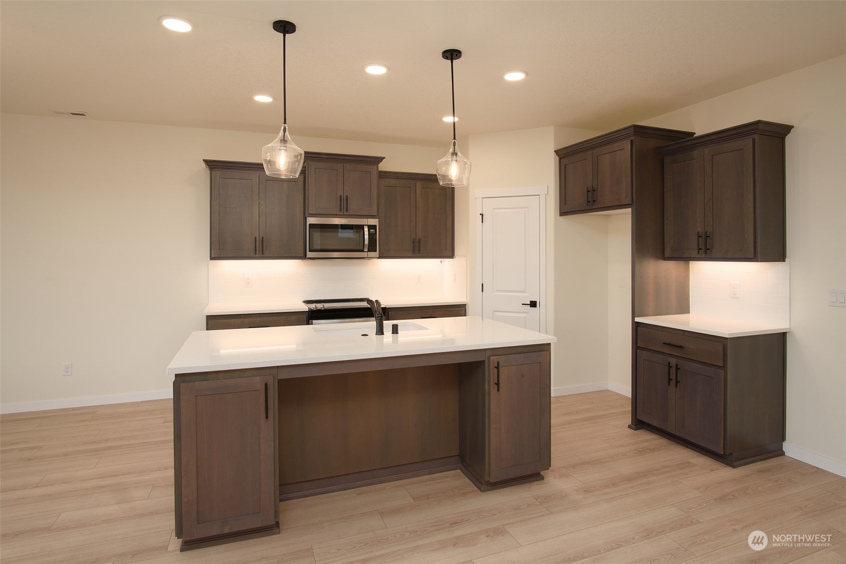 708 Cardinal Avenue Winlock, WA 98596 - Photo 6 of 28 a kitchen with kitchen island stainless steel appliances a sink cabinets and wooden floor