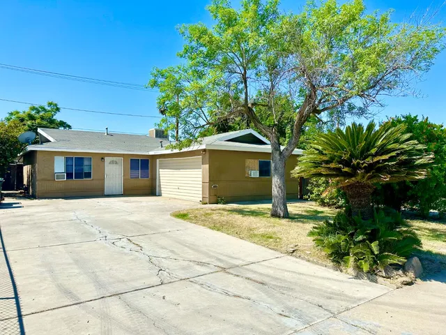a front view of a house with a yard and a garage