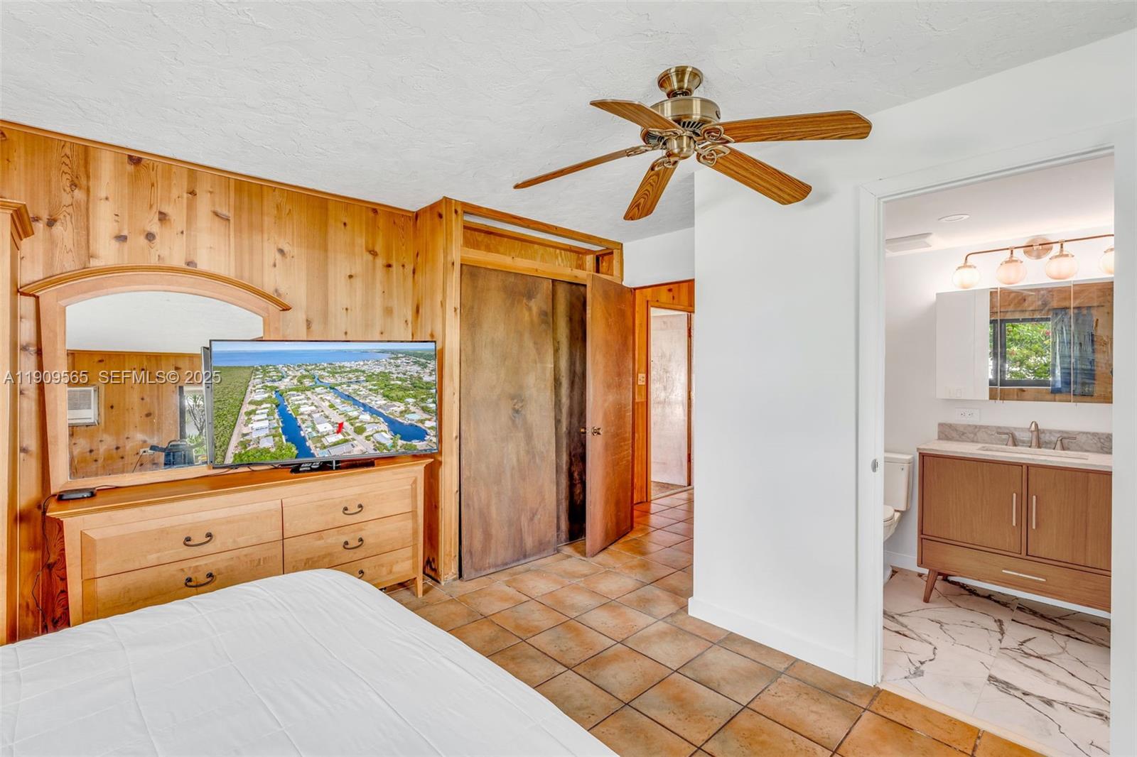877 Ellen Drive Key Largo, FL 33037 - Photo 21 of 39 a bedroom with a bed and a mirror on the dresser