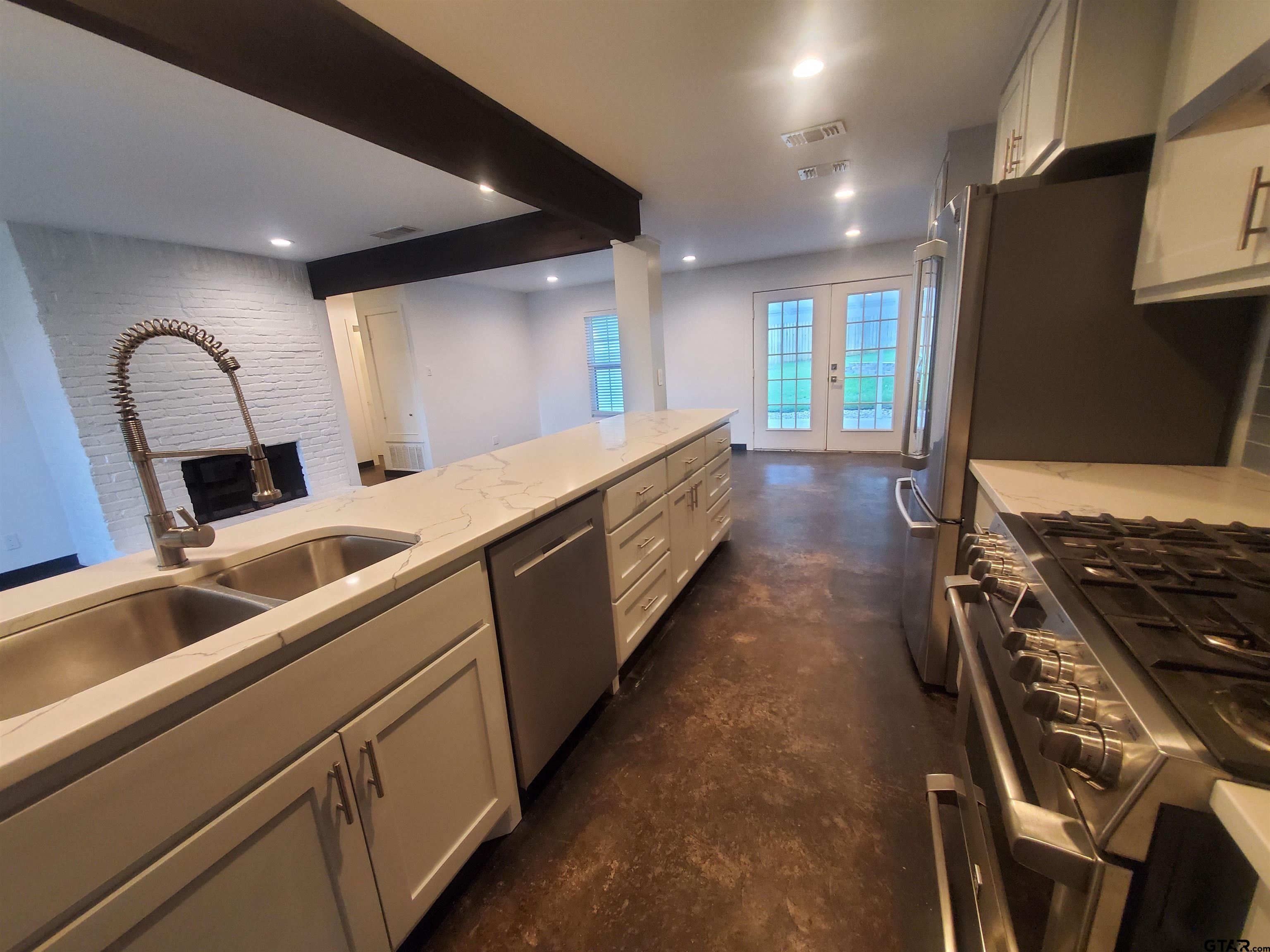 2917 Amy Lane Tyler, TX 75701 - Photo 12 of 36 a kitchen with kitchen island granite countertop a sink stainless steel appliances and cabinets