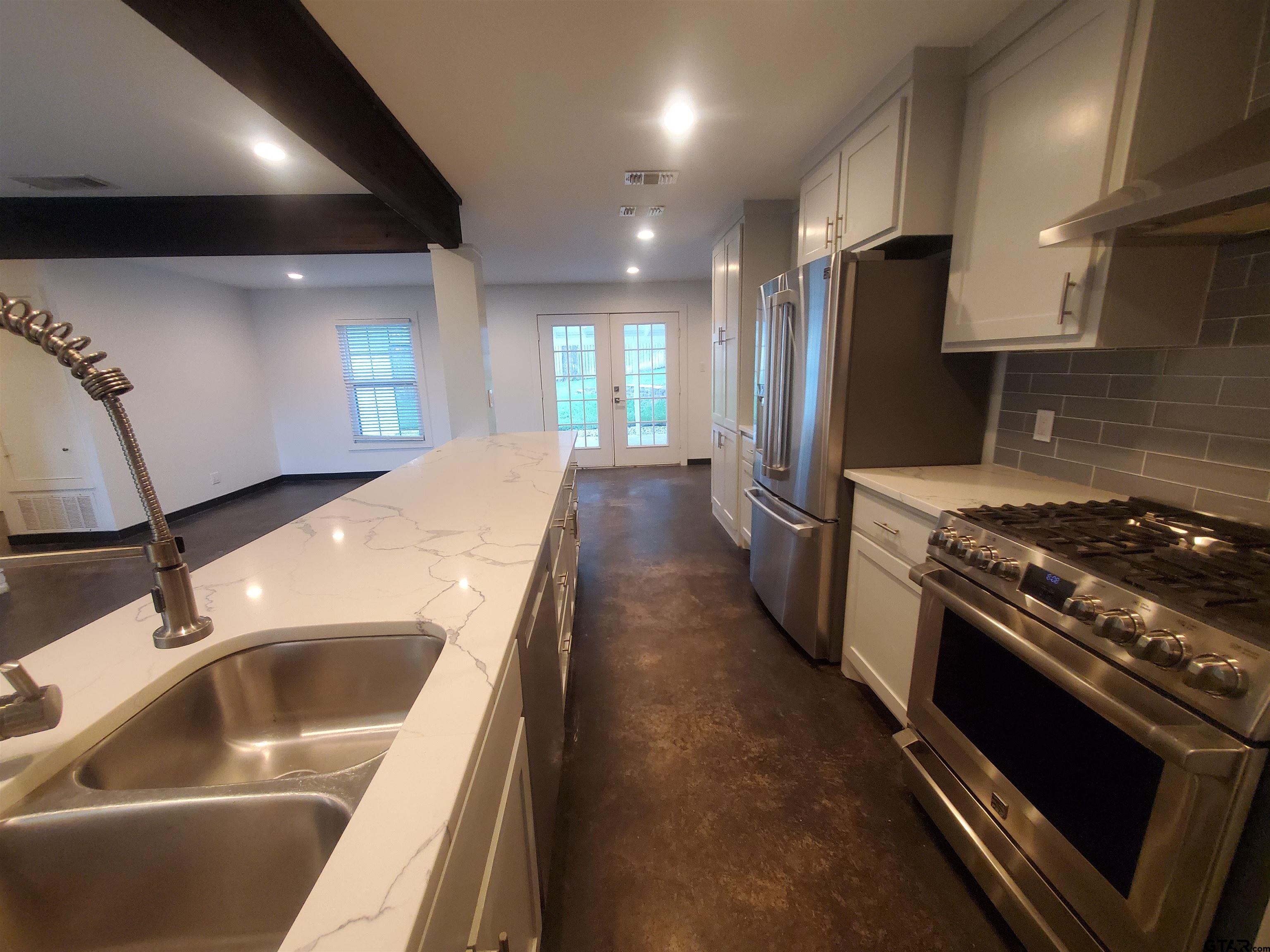 2917 Amy Lane Tyler, TX 75701 - Photo 13 of 36 a kitchen with stainless steel appliances granite countertop a sink a stove and a refrigerator