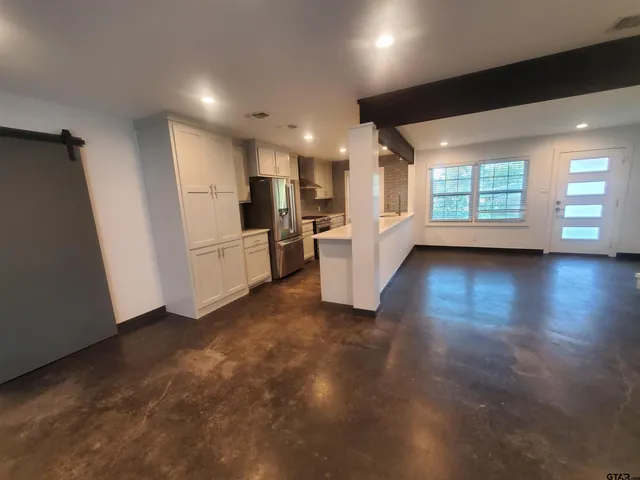 a view of empty room with wooden floor and window
