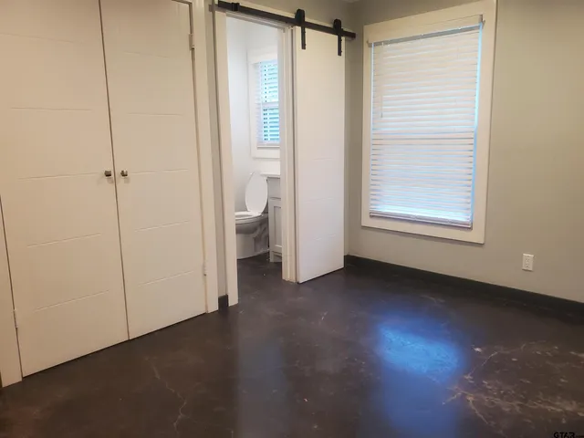 a view of an empty room with a fireplace and a window